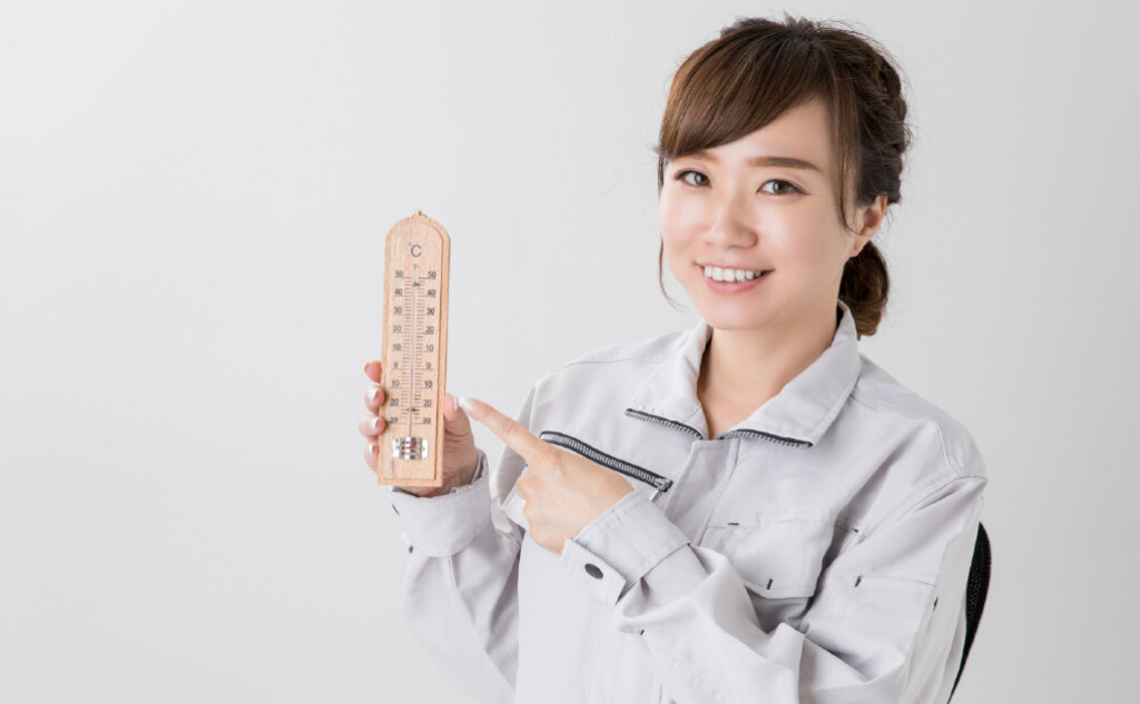 温度計を持つ女性作業員